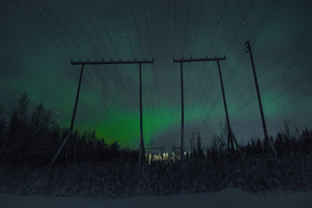 Green aurora borealis in sky behind pylons over Rovaniemi Lapland countrysideの写真素材