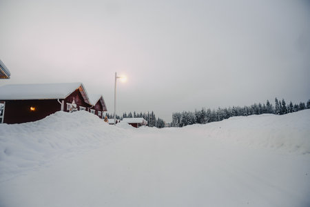 Red houses by streetlight in the snow in winter in Rovaniemi, Laplandの写真素材