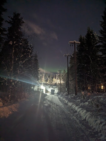 Faint aurora in night sky above bright streetlight in Rovaniemi, Laplandの写真素材