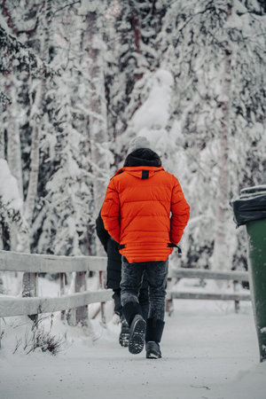 Man in red coat walking through winter wonderland in Ranua, Laplandの写真素材