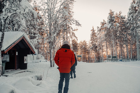 Man in red coat in snowy forest in winter in Ranua, Laplandの写真素材