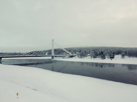 Snowy Ounasvaara hill next to bridge and river in Rovaniemi, Laplandの写真素材