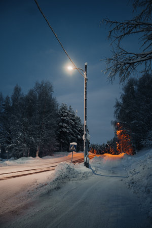 Streetlight over snowy road in Rovaniemi, Lapland in winter twilightの写真素材