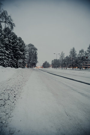 Icy road covered in snow into the centre of Rovaniemi in winter in Laplandの写真素材