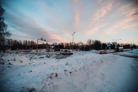 Wide angle view of van on snowy street in Rovaniemi under sunset sky in Laplandの写真素材
