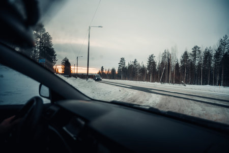 Snowy road outside Rovaniemi shot from car window in Lapland in winter