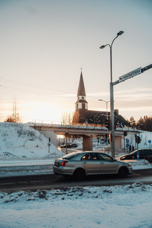 Car driving in front of church in Rovaniemi, Lapland in winter at golden hourの写真素材