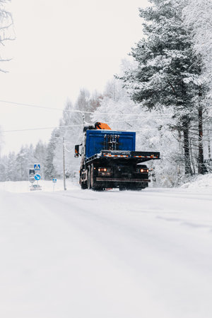 Blue truck on snowy street in winter in Rovaniemi, Laplandの写真素材