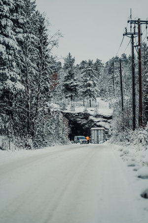 Road to snowy hill next to powerlines in Rovaniemi, Lapland in winterの写真素材