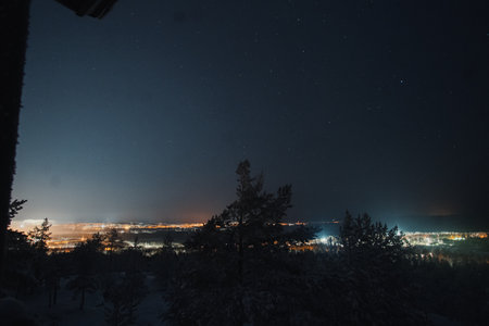 Starry sky over Rovaniemi city lights in winter in Laplandの写真素材