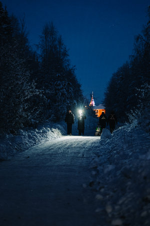 People with flashlight walking down snowy path in Rovaniemi, Laplandの写真素材