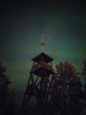 Green aurora borealis behind Syvasenvaara lookout tower in Rovaniemi, Laplandの写真素材