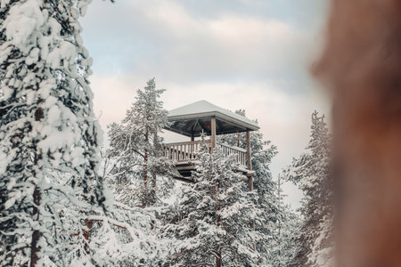 Snowy wooden lookout tower in forest in winter in Rovaniemi, Laplandの写真素材