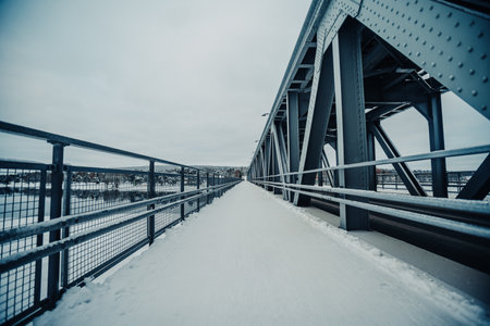 Snowy footpath on railway bridge in Rovaniemi, Lapland over river in winterの写真素材