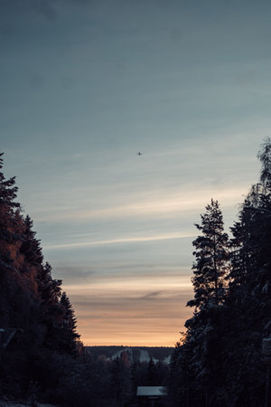 Aeroplane in sunrise sky above Ounasvaara ski resort in Rovaniemi, Laplandの写真素材