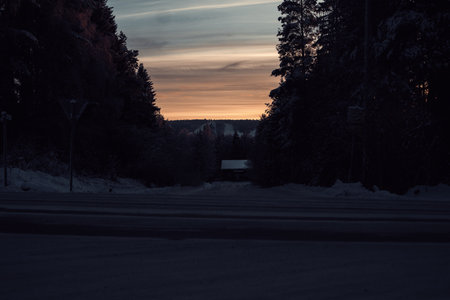 Sunset sky over snowy street in winter in Rovaniemi, Laplandの写真素材