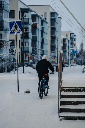 Man on bike on snowy pavement in Rovaniemi, Lapland in winterの写真素材