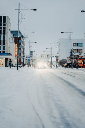 Car turning onto snowy road in winterの写真素材