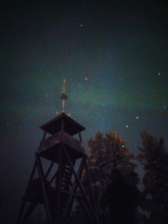 Syvasenvaara lookout tower with aurora in the background in Rovaniemi, Laplandの写真素材