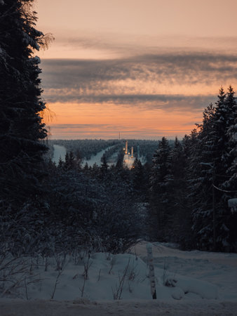Sunset sky over snowy Ounasvaara ski resort ski jumps in Rovaniemi, Laplandの写真素材