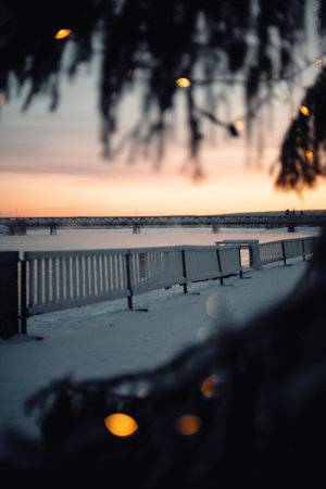 Railway bridge over river in Rovaniemi, Lapland, fairy lights bokeh in winterの写真素材