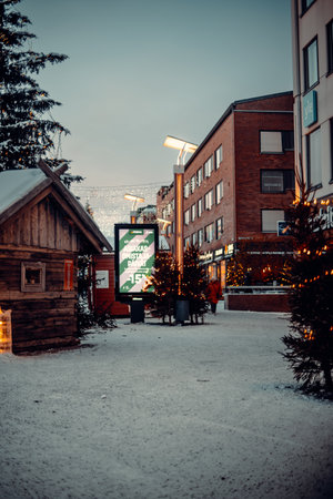 Billboard adverts next to Christmas trees in Rovaniemi, Lapland in winterの写真素材