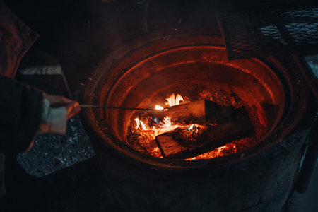 Firewood burning in snowy fireplace at laavu in Rovaniemi, Lapland in winterの写真素材