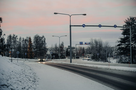 Sunset over snowy highway out of Rovaniemi in winter in Laplandの写真素材