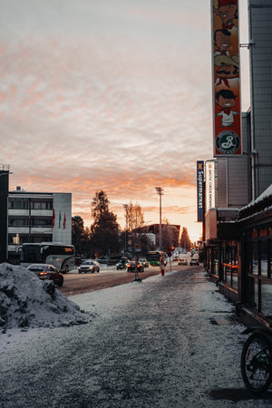 Sun setting over street in the center of Rovaniemi in winter in Laplandの写真素材