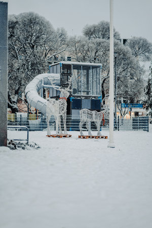 Reindeer models in snow next to childrens play park in Rovaniemi, Laplandの写真素材