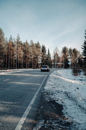 Car on road through Syvasenvaara in Rovaniemi, Lapland in autumnの写真素材