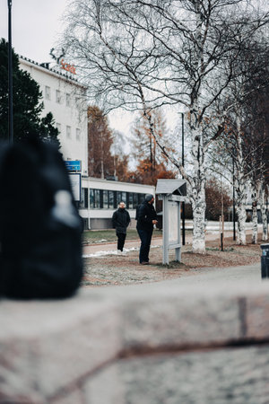 Tourist looking at sign next to Kemijoki in Rovaniemi, Laplandの写真素材