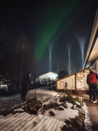 Photographing northern lights over house in Rovaniemi, Laplandの写真素材