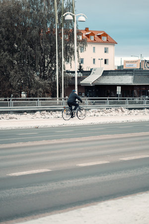Man cycling through snow in Rovaniemi, Lapland in autumnの写真素材
