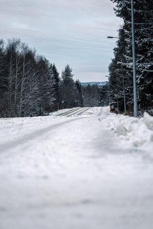 Snowy road through forest in Syvasenvaara in Rovaniemi, Laplandの写真素材