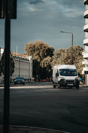 White van on street under grey clouds in London, UKの写真素材