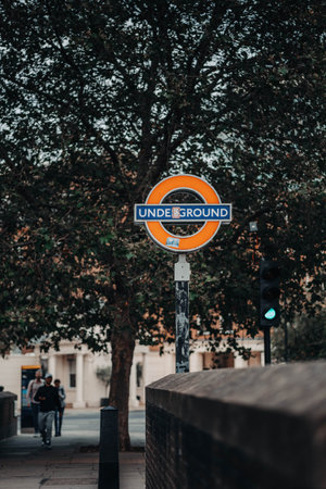 London underground sign in front of tree in London, UKの写真素材