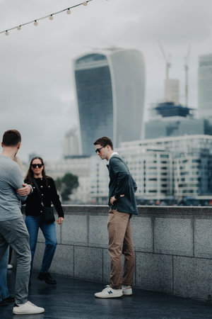 Man in beige trousers stood in front of City of Londonの写真素材