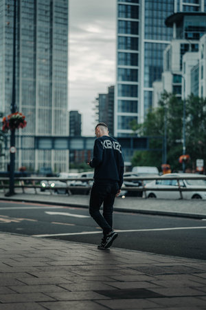 Man on phone walking outside Vauxhall station in London, UKの写真素材