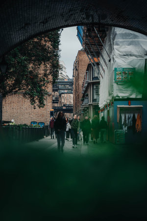 People walking down Victorian street in London, UKの写真素材