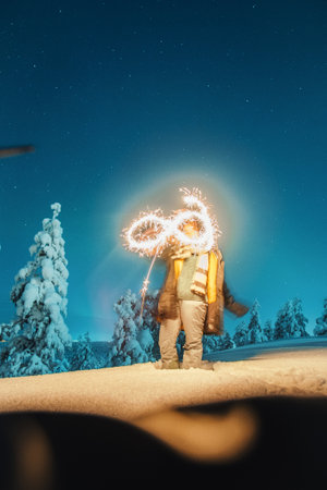 Girl with sparkler in snowy winter forest in Rovaniemi, Laplandの写真素材