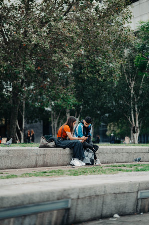 Couple on phone in parkの写真素材