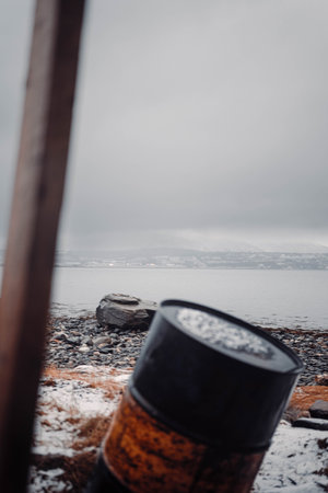 Barrel and rocks on arctic fjord beach near Tromso, Norway in autumnの写真素材