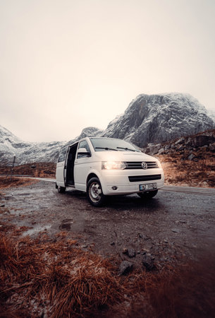 White van parked by road through arctic mountains near Tromso, Norway