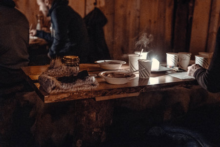 Reindeer soup and hot drinks on table in wooden hut near Tromso, Norwayの写真素材