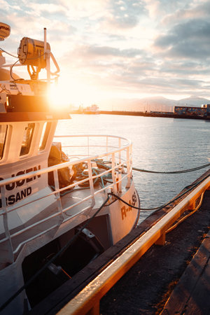 Golden hour sunlight over the front of fishing boat in Tromso harbour, Norway