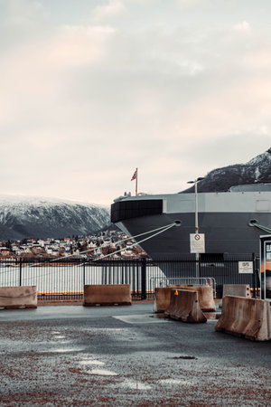 Norwegian flag on the front of boat in Tromso harbour, Norway in autumnの写真素材