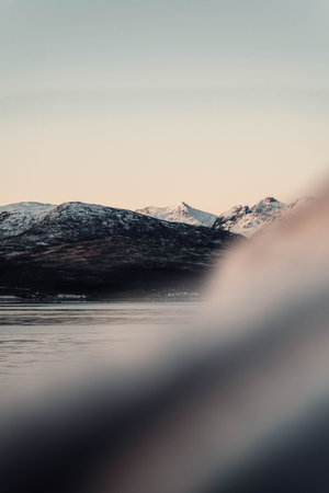Bit of snow on arctic mountains near Tromso, Norway next to fjord in autumn