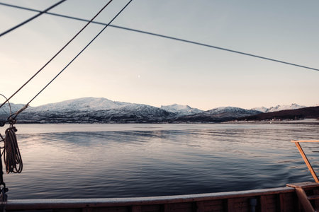 Landscape shot of arctic mountains next to fjord from boat, Tromso, Norway