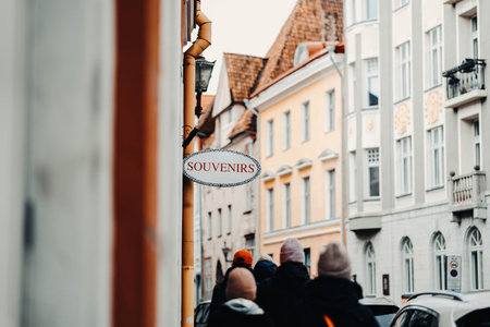 Tourists walking under a souvenir shop sign on street in Tallinn, Estoniaの写真素材